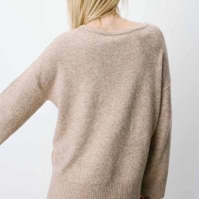 Camisola bege de malha vista de trás com gola redonda e textura macia.