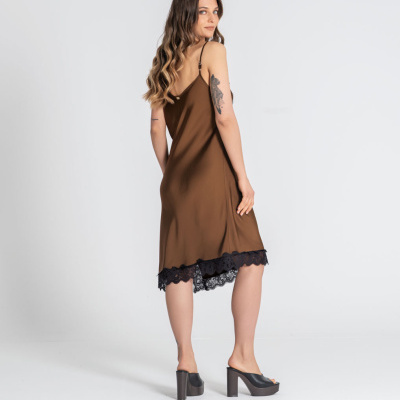 Vestido castanho com renda preta na bainha, usado por mulher em fundo branco.