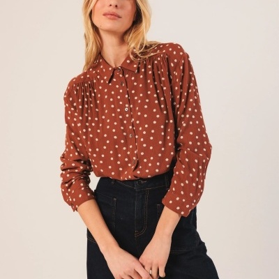 Camisa castanha com bolas brancas e calças pretas