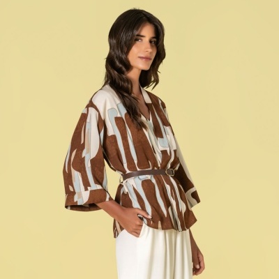 Blusa castanha e azul claro com cinto castanho e calças brancas largas