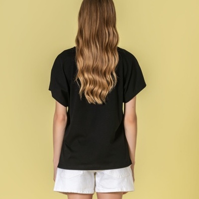 Pessoa de costas com camisola preta de manga curta e calções brancos