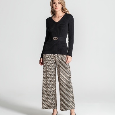 Mulher com camisa preta e calças às riscas diagonais em fundo branco