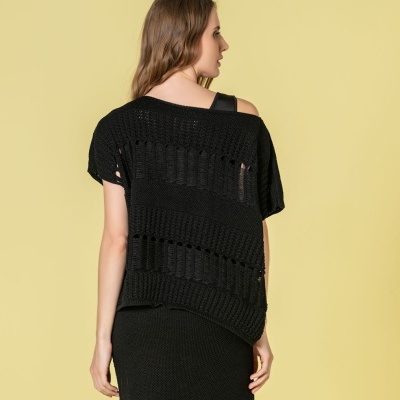 Mulher de costas com camisola preta de malha e saia preta