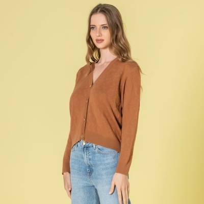 Camisola castanha de malha com botões dourados e calças de ganga azul