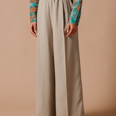 Calças largas bege com cinto castanho e blusa azul com padrão