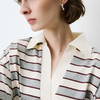 Blusa de malha riscada em cinza, creme e castanho com gola creme, usada por modelo