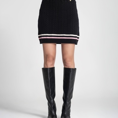Saia curta preta de malha com riscas branca e rosa na barra e botas pretas de couro