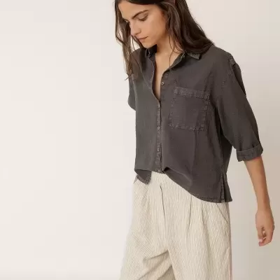 Camisa cinza escuro e calças largas bege com riscas