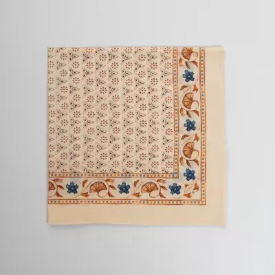 Lenço de tecido creme com padrão floral e triângulos castanhos e azuis