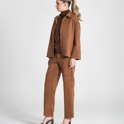 Mulher com conjunto castanho de camisa e calças aveludadas