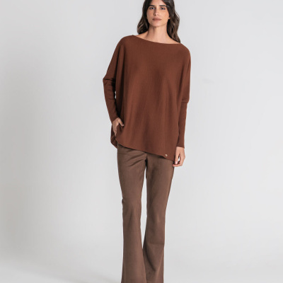 Mulher com blusa castanha de manga comprida e calças castanhas