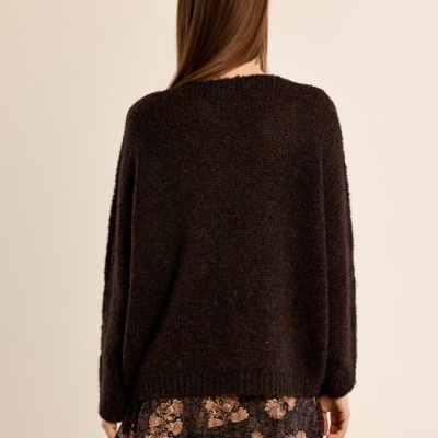 Camisola preta de malha e saia preta com padrão floral vista de costas