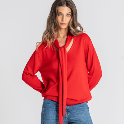 Blusa vermelha feminina com laço no decote e calças de ganga azul claro