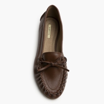 Sapato mocassim castanho com laço em pele sobre fundo branco