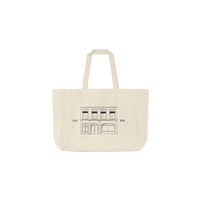 Saco de tecido bege com desenho de edifício e texto EST. 2011