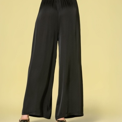 Calças largas pretas de tecido fluido com cintura elástica vistas da parte traseira