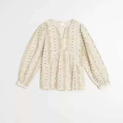 Blusa branca com padrão geométrico verde e dourado e mangas compridas.