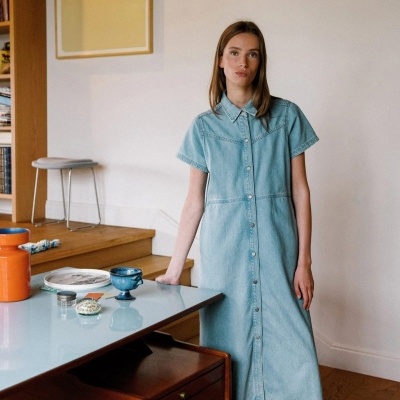 Vestido comprido de ganga azul claro com botões frontais numa mulher