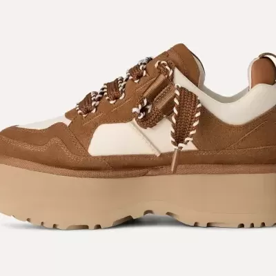 Ténis unissexo castanho com sola plataforma bege e atacadores trançados.