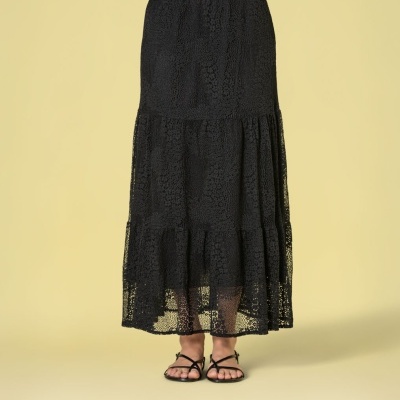 Saia preta rendada comprida com padrão floral e sandálias pretas