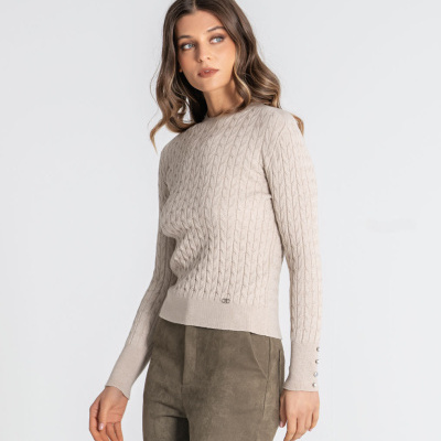 Mulher com camisola bege de malha e calças verde-oliva