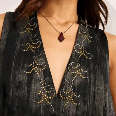 Vestido preto com bordados dourados e prateados e colar com pendente vermelho