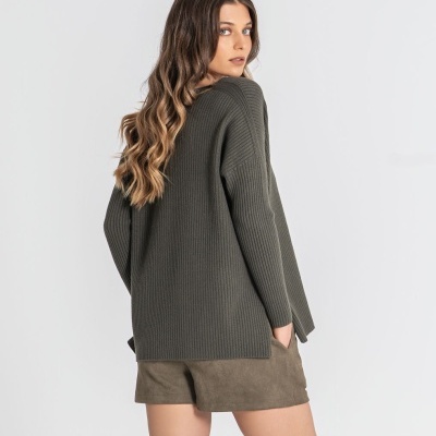 Mulher com camisola de malha cinza escura e calções castanhos de camurça vista de costas