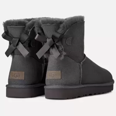 Botas UGG cinza escuro com laços pretos e etiqueta UGG no salto