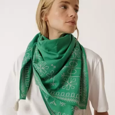 Lenço verde bordado com franjas pompom usado por mulher