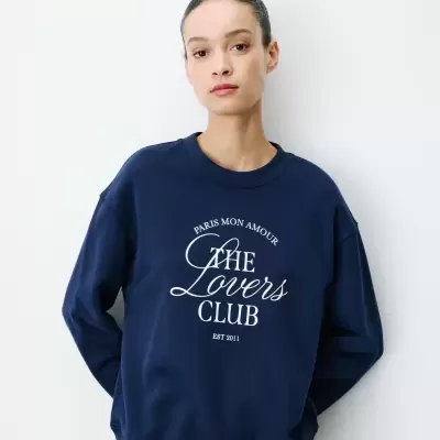 Mulher a usar sweatshirt azul escuro com texto branco