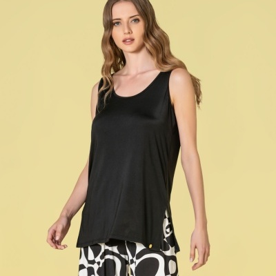 Mulher com camisola preta sem mangas e calças com padrão gráfico preto e branco.