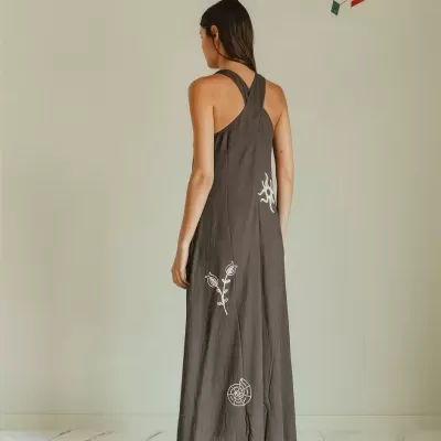 Vestido longo cinzento escuro com alças cruzadas e bordados brancos vistos de costas