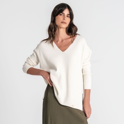 Mulher com camisola branca canelada e saia verde-oliva