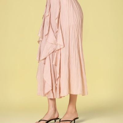 Saia comprida rosa clara com folhos e sandálias pretas simples