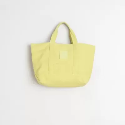 Mala tote amarela de tecido com duas pegas e etiqueta frontal