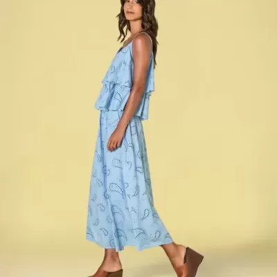 Blusa e saia azul claras com padrão de gotas e sandálias de cunha castanhas