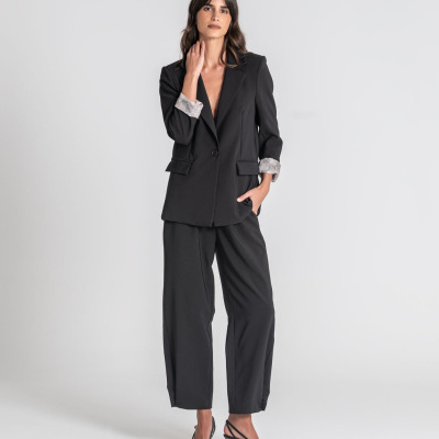 Fato feminino preto com blazer e calças largas em fundo branco