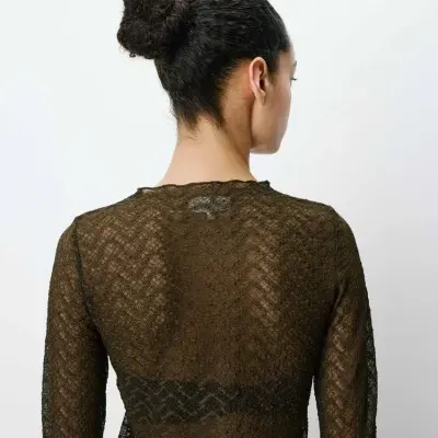 Top feminino preto em renda transparente visto de costas com padrão ondulado