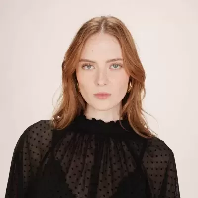 Blusa preta transparente com pontos usados por mulher ruiva