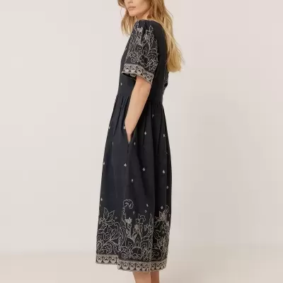 Vestido midi preto bordado com sapatos baixos castanhos