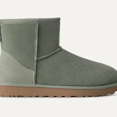 Bota baixa cinzento-esverdeada de camurça com sola castanha e etiqueta UGG.