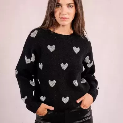 Camisola preta com padrão de corações brancos e calças pretas brilhantes