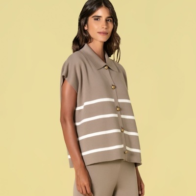 Colete de malha castanho claro com riscas brancas e botões dourados junto com calças castanhas.