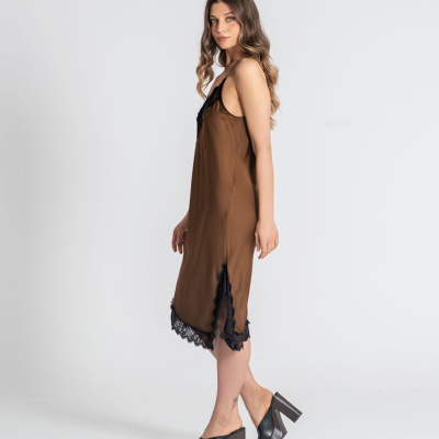 Vestido castanho com renda preta e sapatos de salto preto num fundo branco