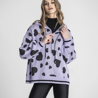 Mulher a usar camisola lilás com corações pretos e calções justos pretos