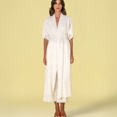 Vestido branco comprido com bordado vazado e pompons, usado com sandálias castanhas