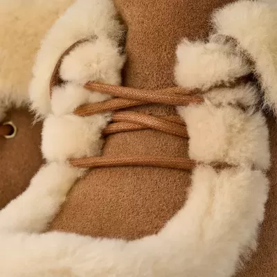 Botas castanhas em camurça com pêlo branco ao redor e atacadores castanhos