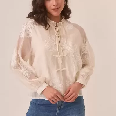 Blusa feminina bege transparente bordada com calças de ganga azul