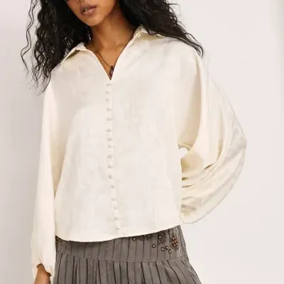 Blusa branca com padrão jacquard e botões forrados, mangas largas.