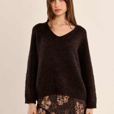 Camisola preta de malha e saia preta com padrão floral castanho